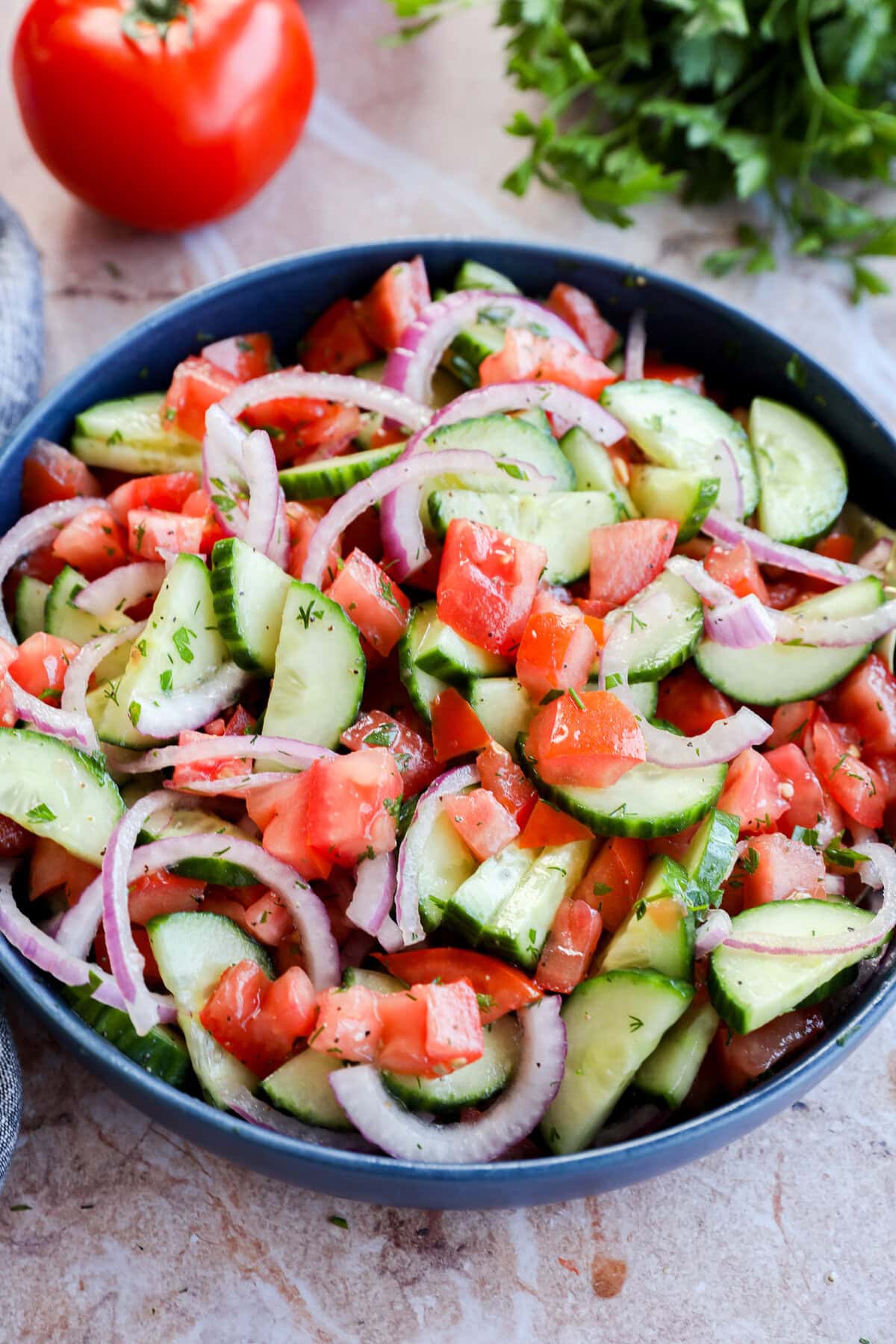 Vegetables and herbs in the background of a bowl with tons of fresh veggies for a summer side dish