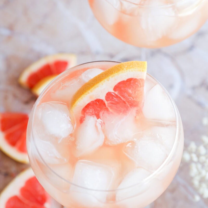 Rosé Elderflower Spritz Cocktail in stemmed wine glasses with fresh grapefruit wedges