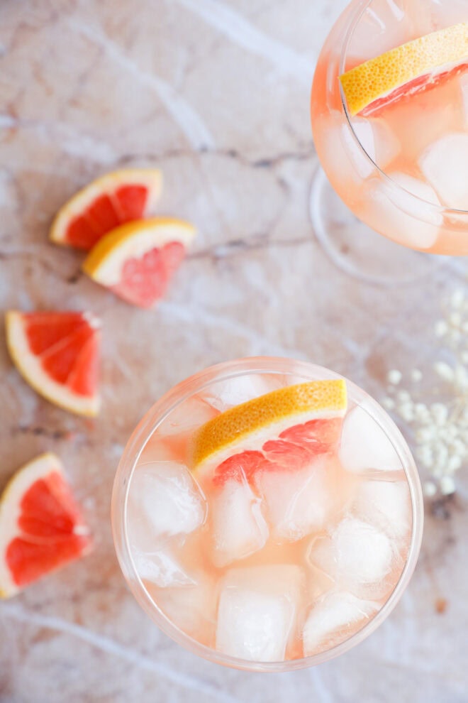 Wine elderflower drink in a stemmed wine glass with fresh grapefruit and baby's breath