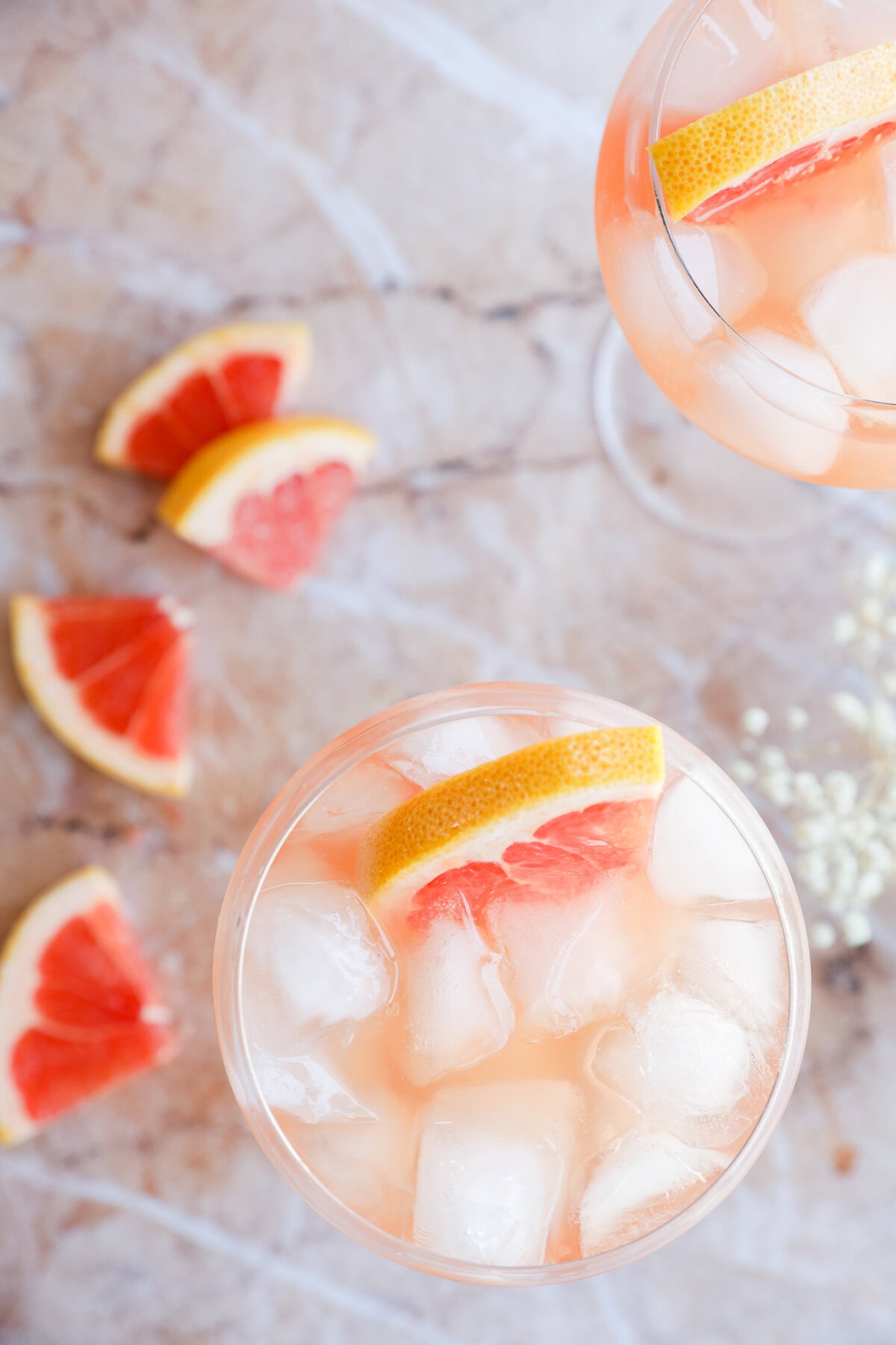 Wine elderflower drink in a stemmed wine glass with fresh grapefruit and baby's breath