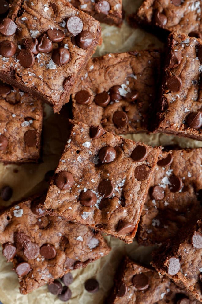 pile of chocolate chocolate chip cookie bars on brown parchment paper