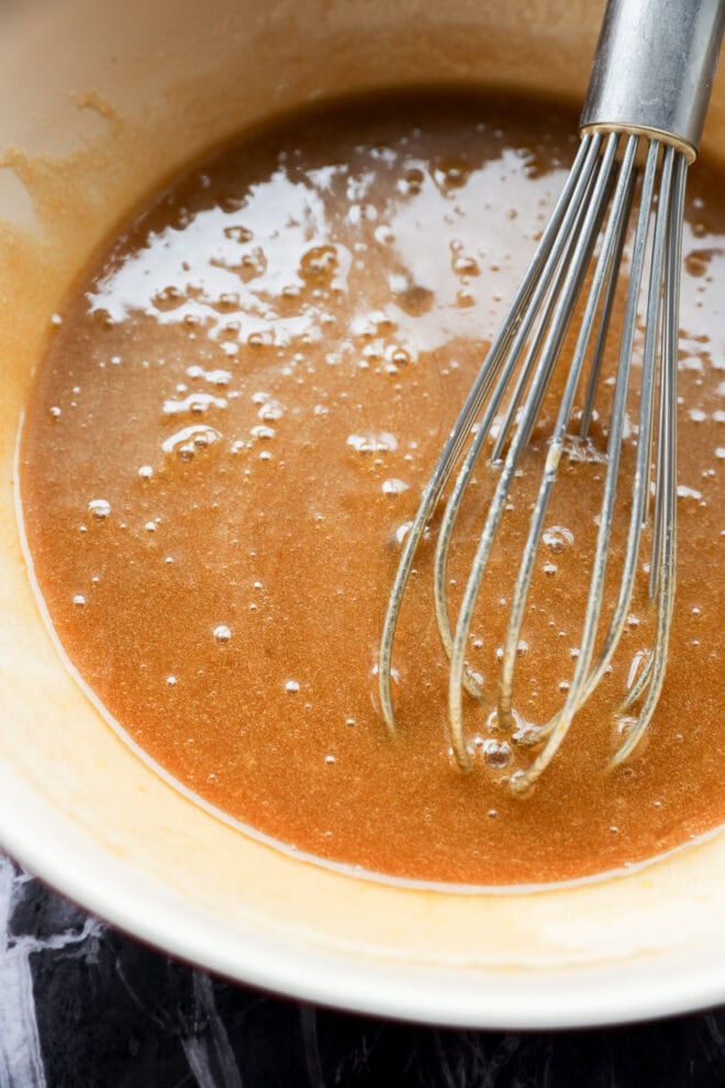 mixing together wet ingredients in a bowl with a whisk