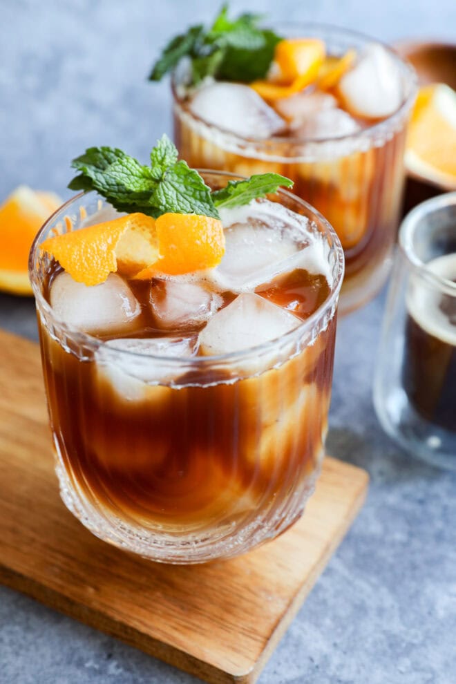 glasses of iced coffee with mint sprigs and orange peel