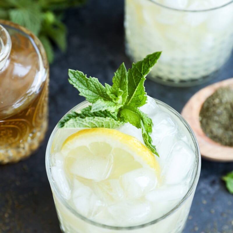 Green tea cocktail in glasses with fresh lemon slices and mint leaves in them