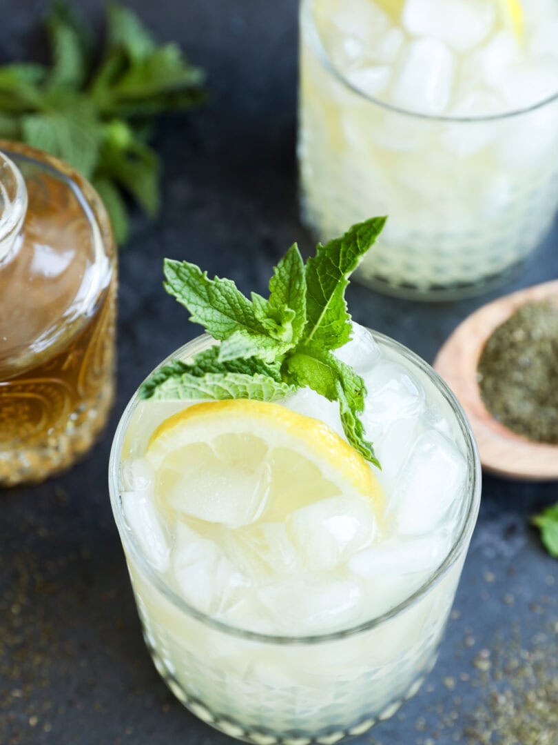 Green tea cocktail in glasses with fresh lemon slices and mint leaves in them