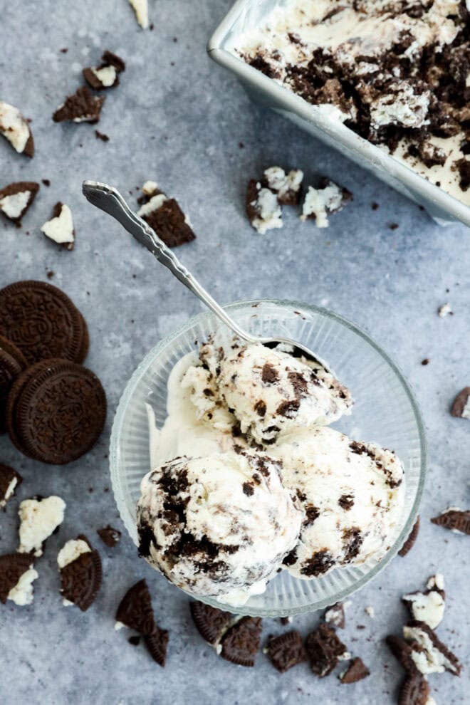 Cookies and cream ice cream in bowl with spoon and cookies around it