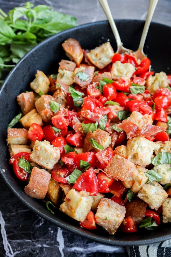 Panzanella Toscana in large black bowl with gold serving bowls