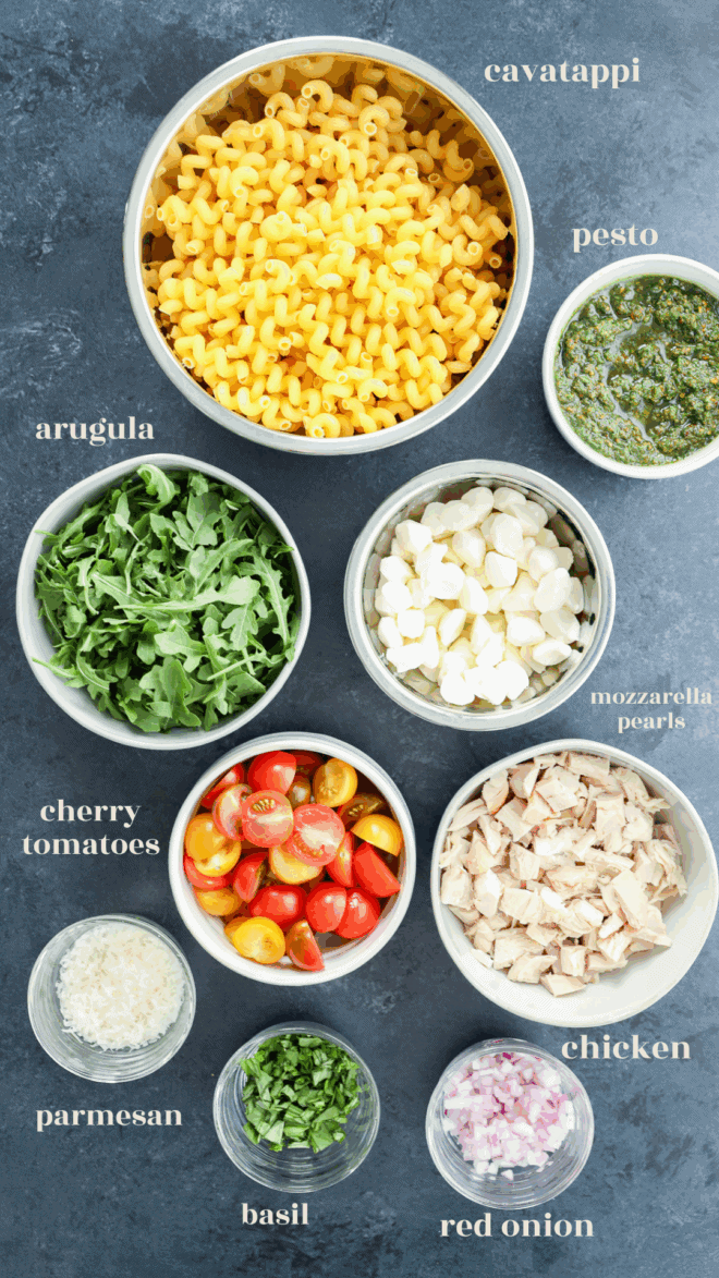 pesto chicken pasta salad ingredients in bowls with text labels