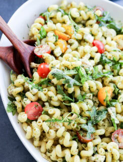 close up of pasta tossed with pesto and other fresh ingredients