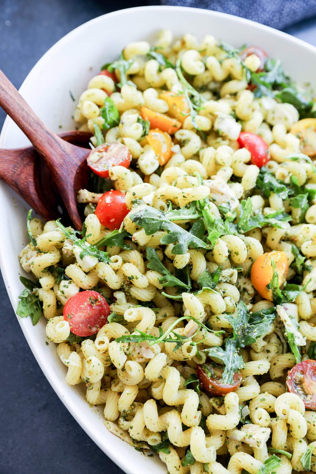 close up of pasta tossed with pesto and other fresh ingredients