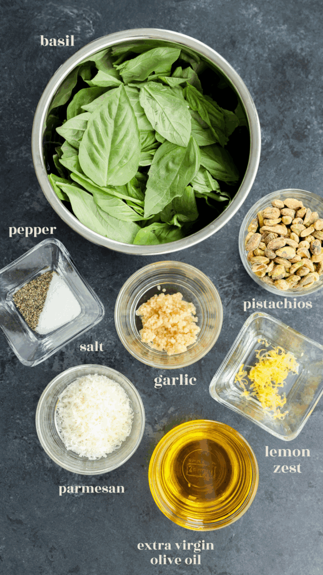 Pistachio pesto ingredients in bowls with text labels