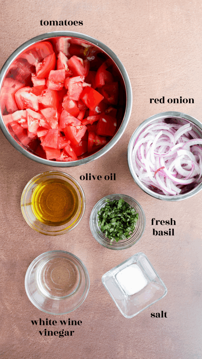 Tomato onion salad ingredients in bowls with text labels