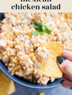 A hand holds a tortilla chip topped with flavorful Mexican chicken salad, loaded with corn, herbs, and tender chicken pieces, above a bowl of the same delicious salad. Text reads Mexican chicken salad and www.cakenknife.com.