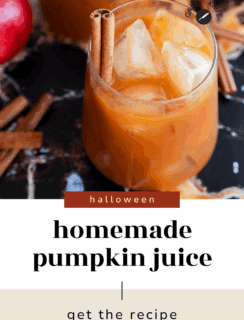 A glass of homemade pumpkin juice with ice cubes and cinnamon sticks sits on a dark marble surface, next to an apple and more cinnamon sticks. Text reads: Spooky Halloween pumpkin juice – get the recipe.