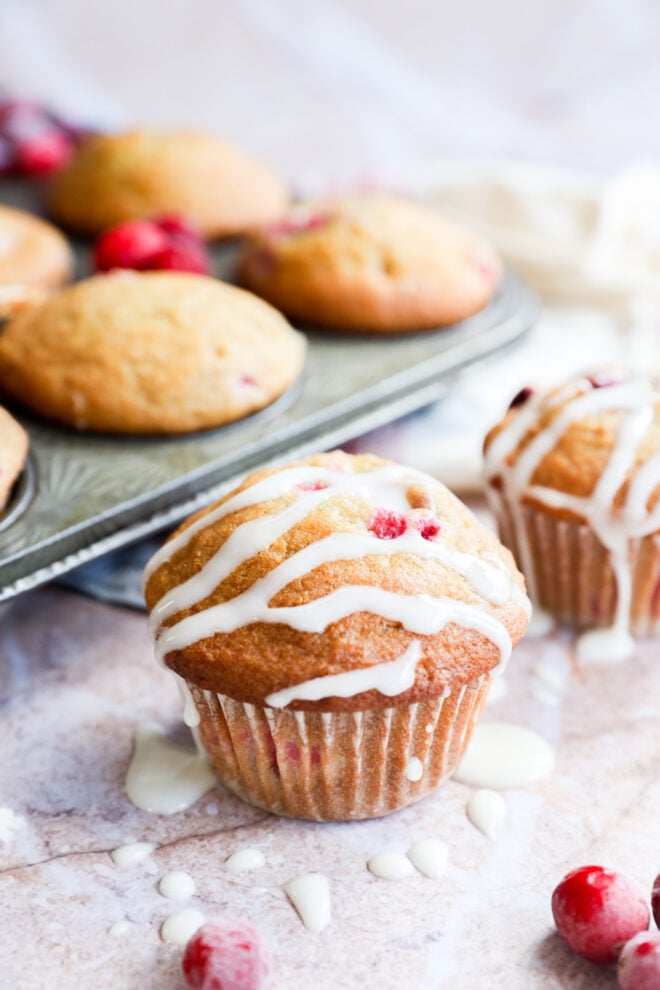 A close-up of a glazed baked goods next to the muffin tin.