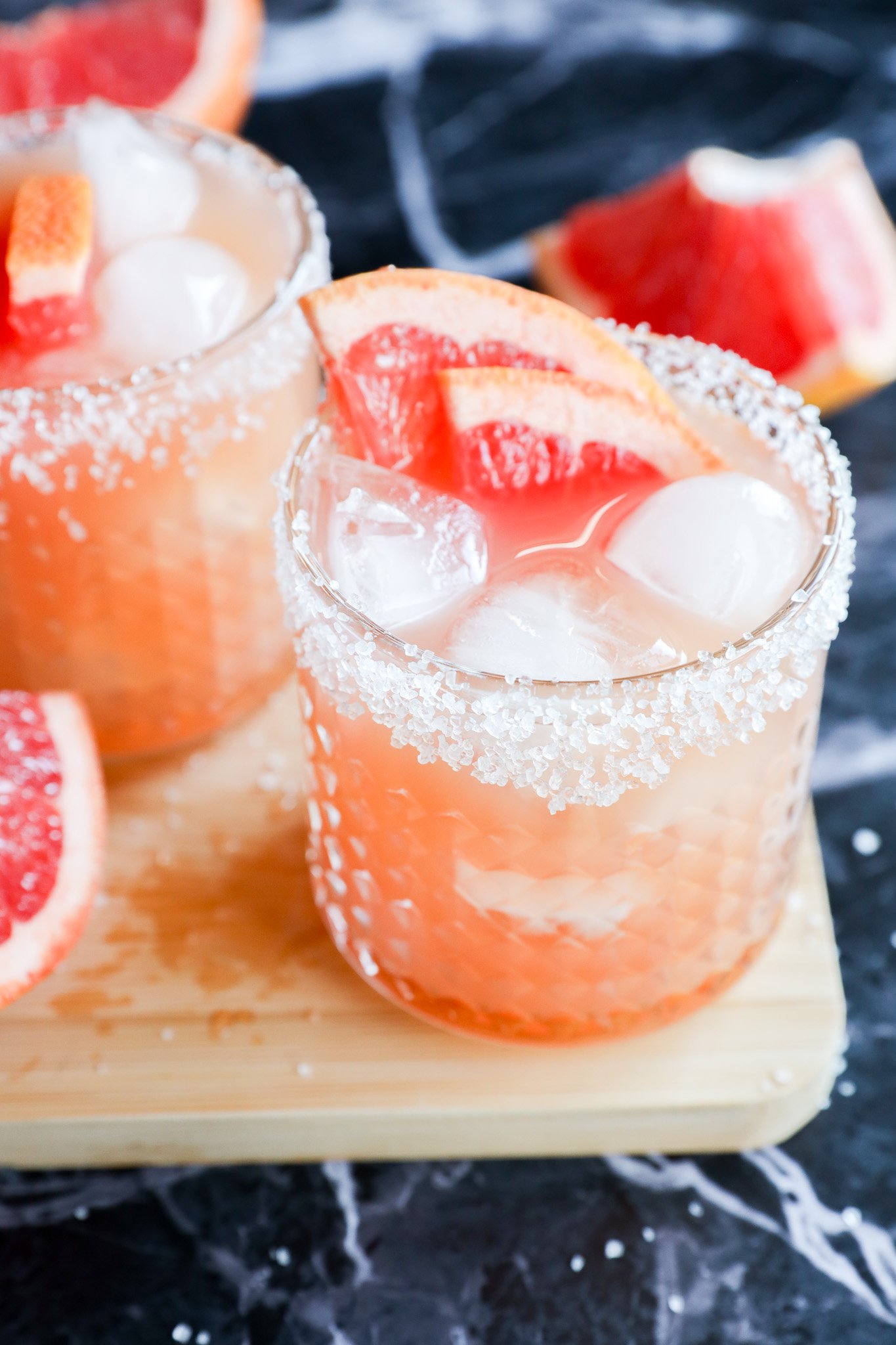 Two glasses with salt-rimmed edges are filled with a refreshing drink and elegant touch.