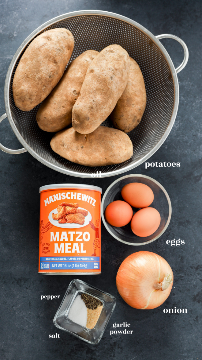 A colander with russet potatoes, a bowl of three eggs, a can of Manischewitz matzo meal, a yellow onion, and a dish with salt, pepper, and garlic powder—all labeled