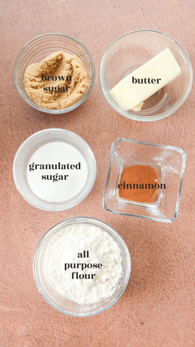 Five small glass bowls on a pink surface contain the key ingredients for the streusel topping
