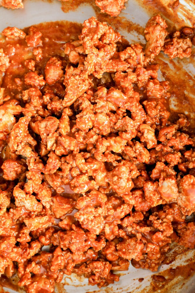 Cooked ground meat coated in a reddish-brown sauce, likely seasoned with spices, fills the view. The mixture appears moist and chunky