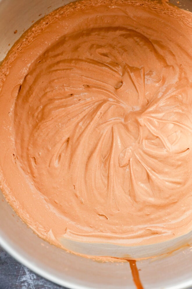 A close-up of a mixing bowl filled with smooth, creamy chocolate batter&mdash;swirled in circular patterns