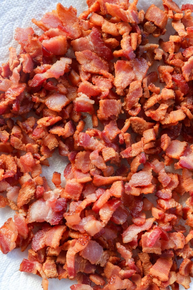 A pile of cooked, chopped bacon bits on a paper towel.
