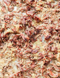 A close-up view of shredded instant pot carnitas with browned, crispy edges.