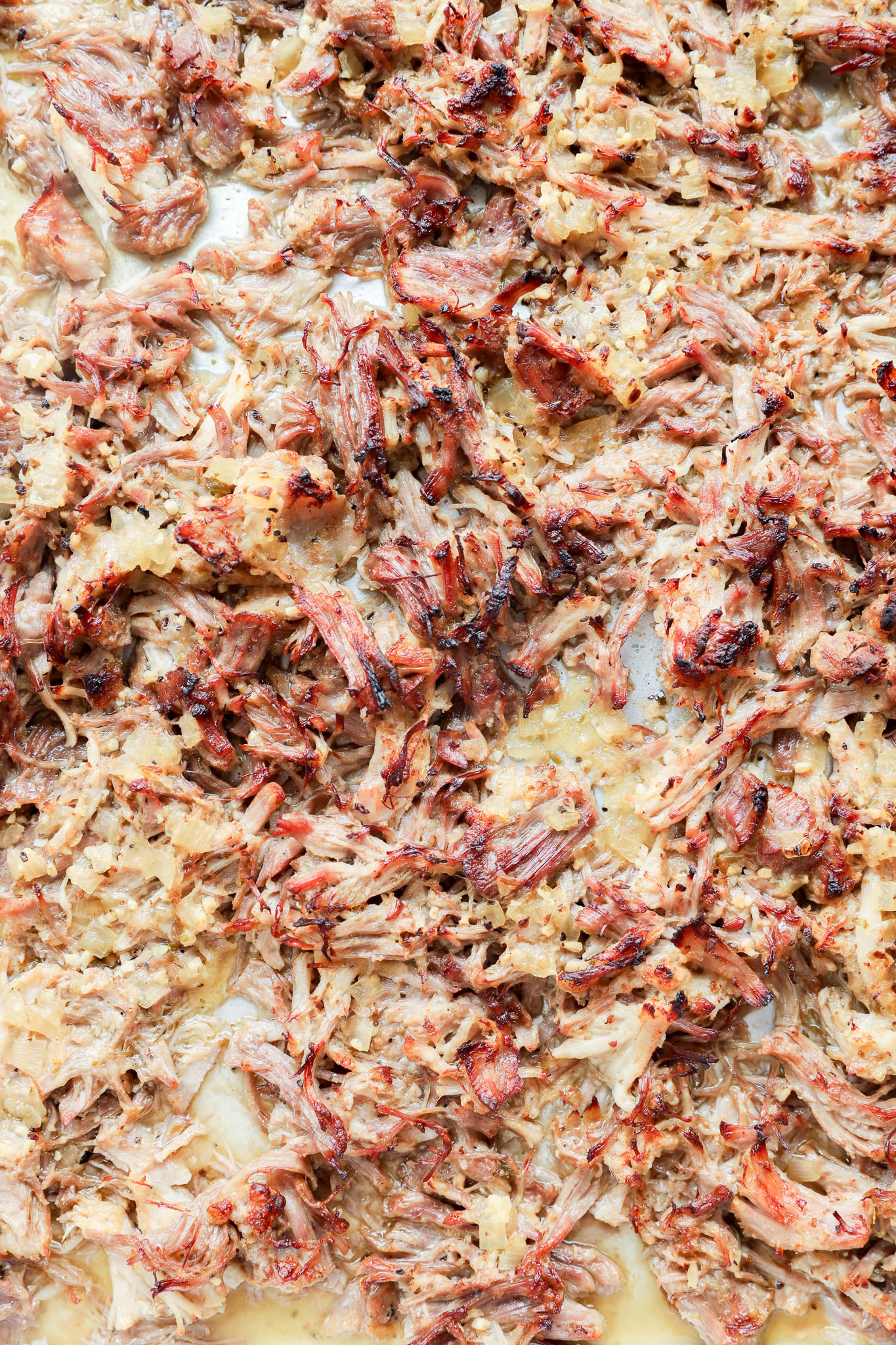 A close-up view of shredded instant pot carnitas with browned, crispy edges.