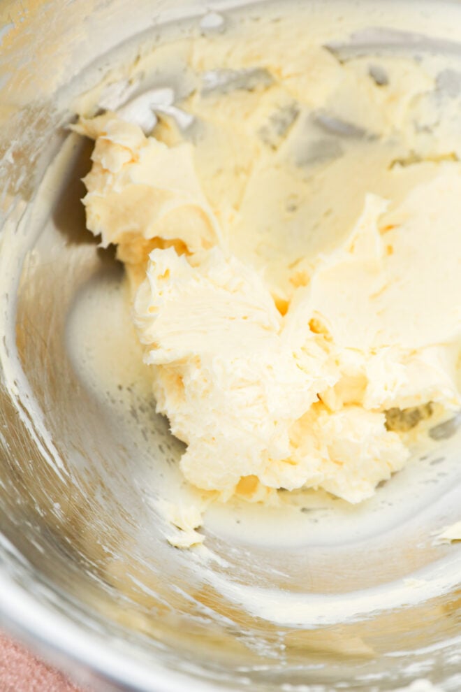 Softened butter whipped in a stainless steel mixing bowl.